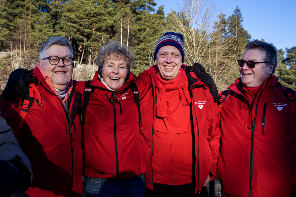 Fire personer, en dame og tre menn, som smiler.